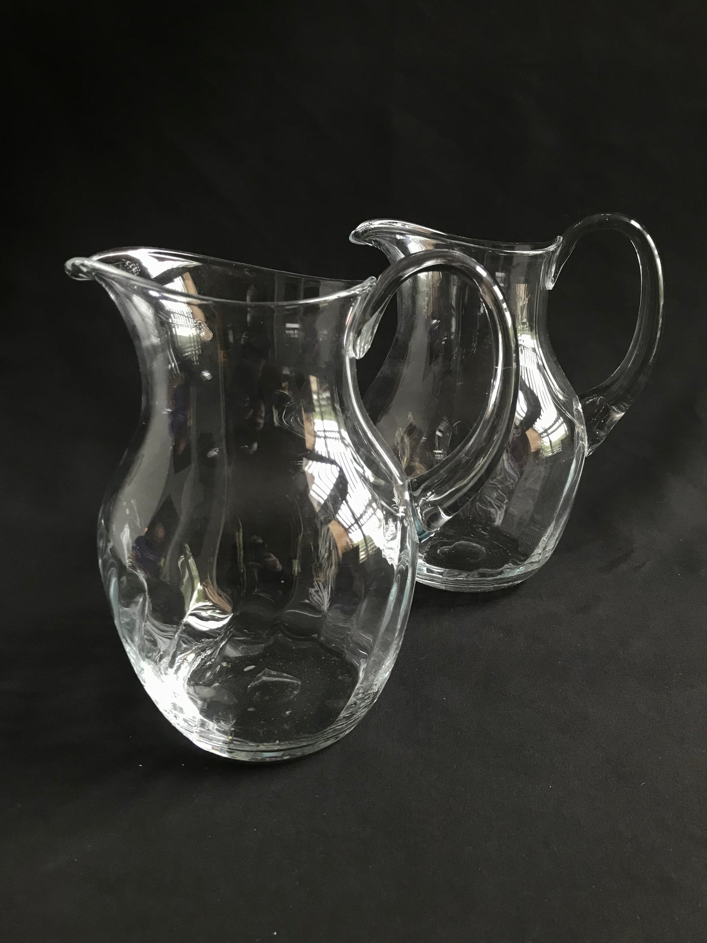 Pair of clear glass water pitchers.